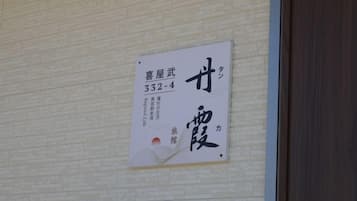 Parede com placa indicando o número do quarto 332-4, com caracteres japoneses e ilustração de uma cena tradicional japonesa.