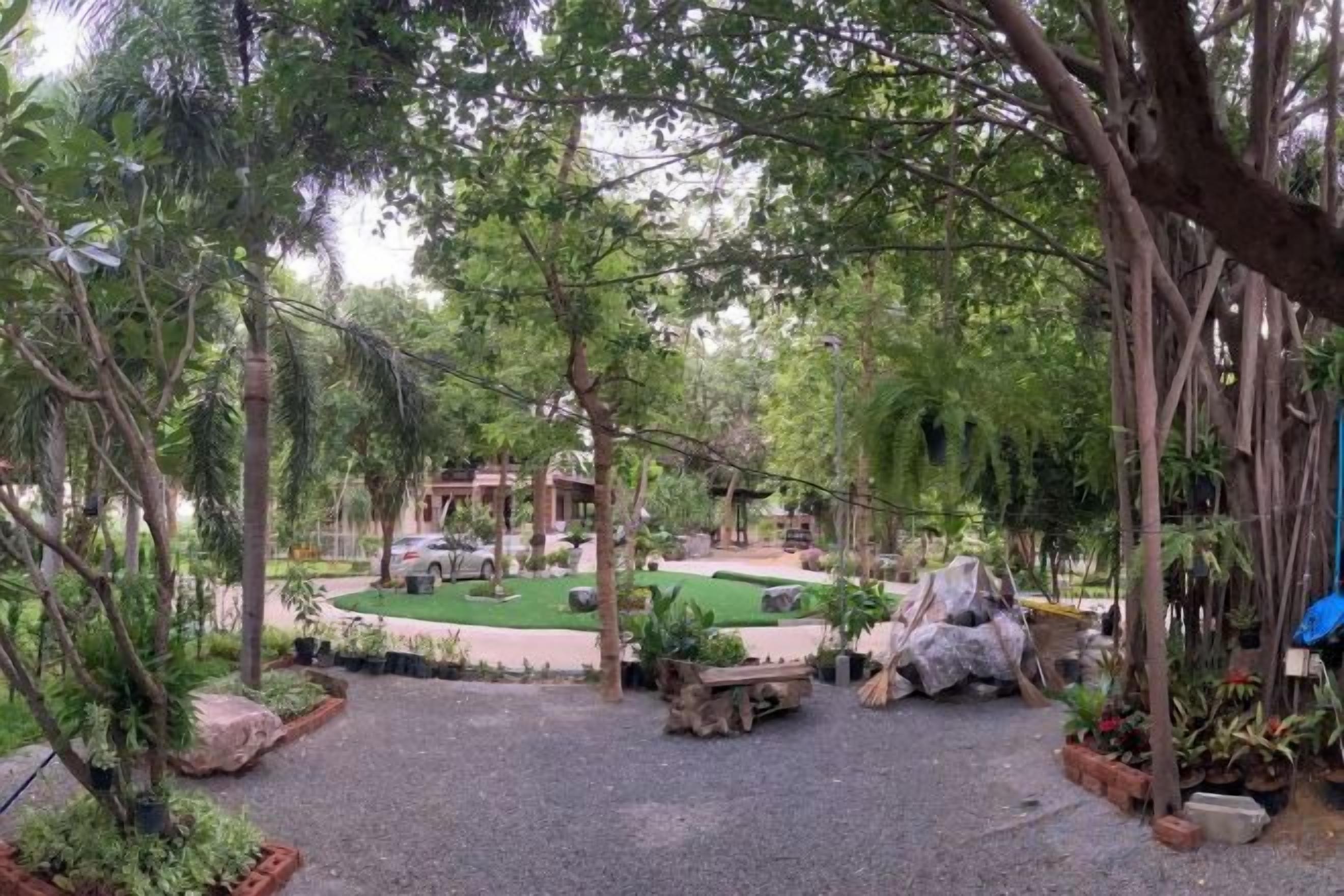 A landscaped outdoor area with a circular seating arrangement, surrounded by trees and plants.