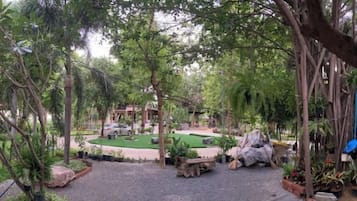 A landscaped outdoor area with a circular seating arrangement, surrounded by trees and plants.