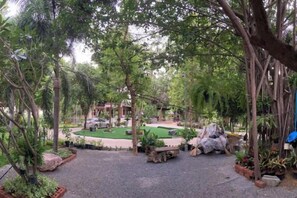 A landscaped outdoor area with a circular seating arrangement, surrounded by trees and plants.