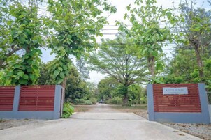 A gated entrance with a sign, surrounded by trees.