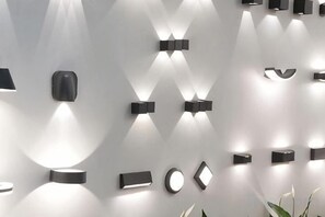 A wall with variously shaped wall-mounted lights. - Erykah Hotel Mityana Road (Mawokota)