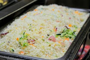 A tray of cooked rice with vegetables. - Erykah Hotel Mityana Road (Mawokota)