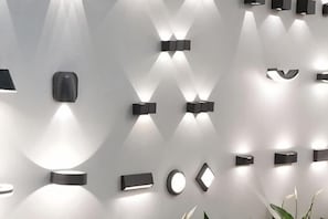 A wall with variously shaped wall-mounted lights.