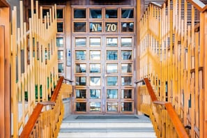 Une entrée d’immeuble avec une façade en bois et un escalier menant à l’étage supérieur.