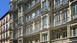 Een meerhoog gebouw met versierde balkons en klassieke architectuurelementen.