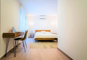 A bedroom with a bed, a desk, and a chair.