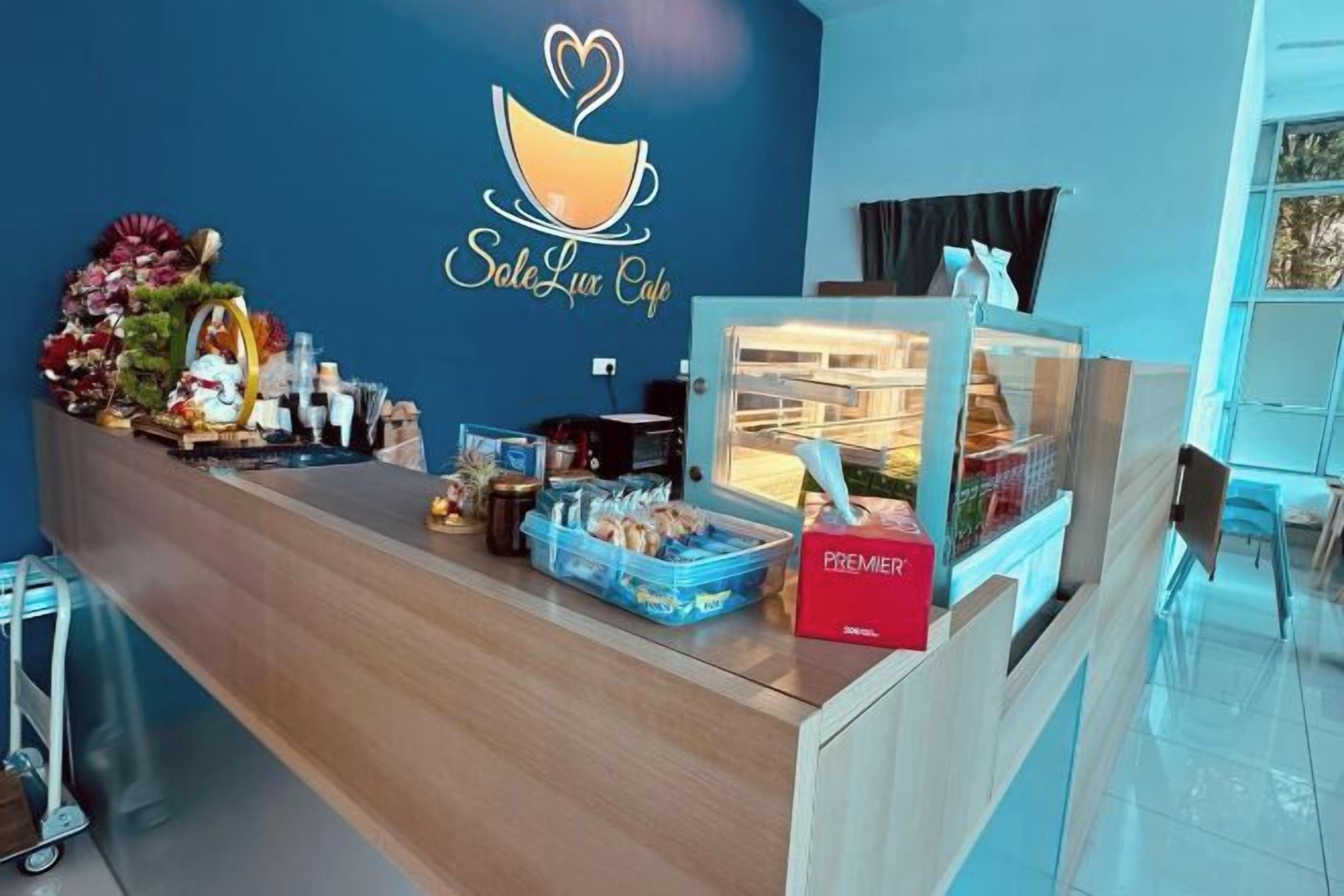Zona de recepció amb un mostrador que mostra diversos aliments i el logotip d'una cafeteria.