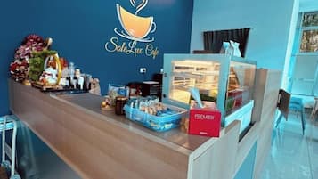Zona de recepció amb un mostrador que mostra diversos aliments i el logotip d'una cafeteria.