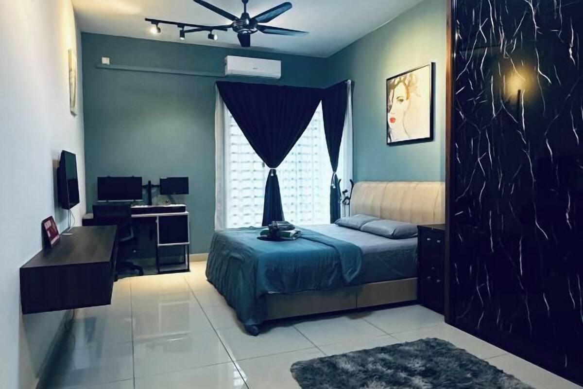 A modern bedroom with a bed, desk, and a ceiling fan.