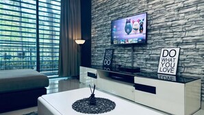 A modern living room with a stone wall, a flat-screen TV, and motivational signs. - Johor Cozy Home 2 Rooms & Easy Parking Fast WiFi ! (Plentong)