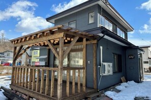 A two-story building with a wooden deck and an attached garage. - Mintmint (Noboribetsu)