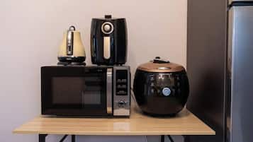 A microwave and a slow cooker on a wooden table.