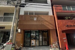 Un edificio con fachada de madera, entrada de vidrio y bicicletas estacionadas afuera.