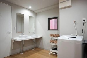 A modern bathroom with two sinks, a large mirror, a towel rack, and a portable heater. - Tasone Urban STAY Osaka NambaWestSTB4F (Osaka)