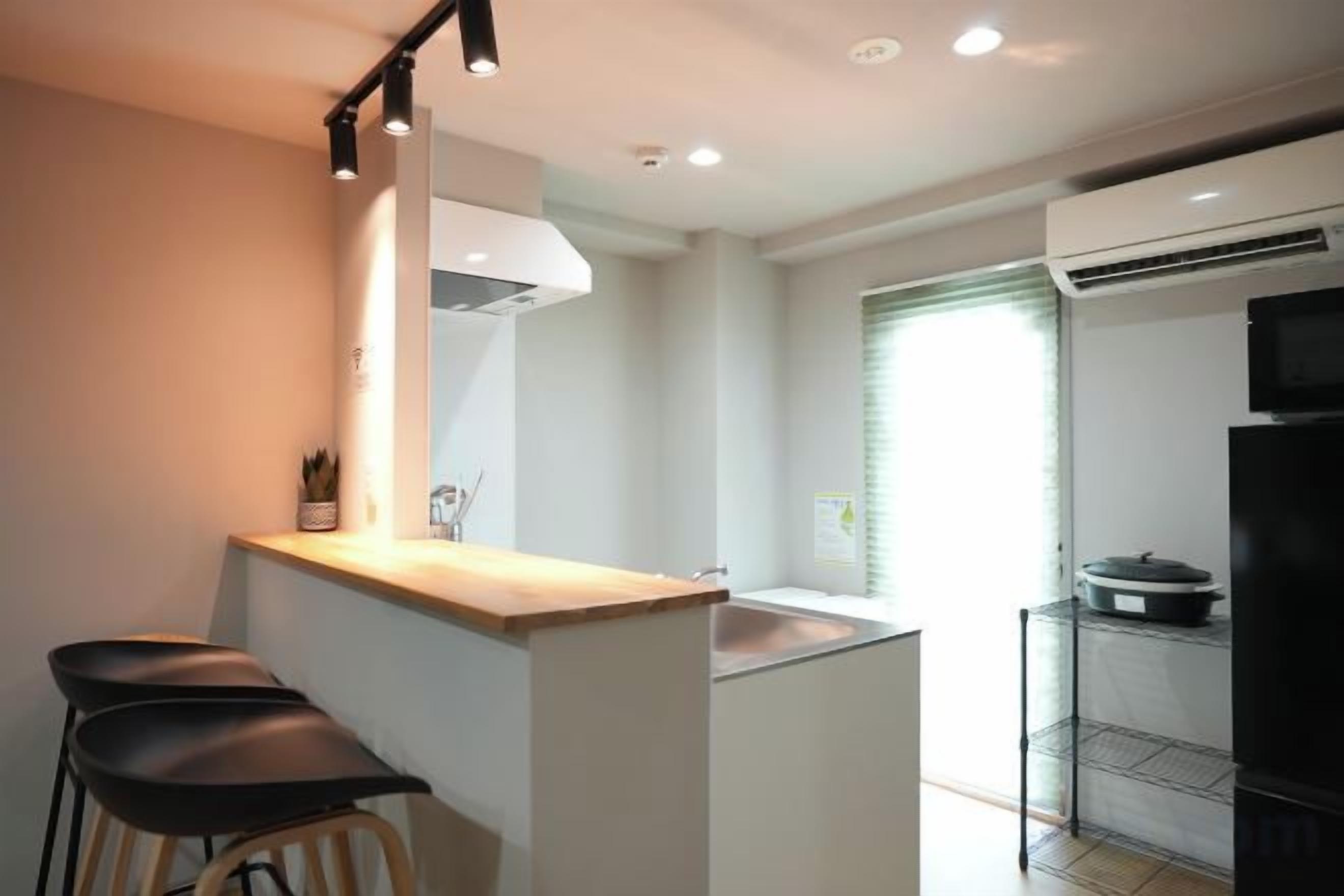 A compact kitchen with a bar area, a sink, and a refrigerator.