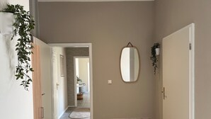 A hallway with a mirror, a door, and a tiled floor. - Holiday Apartment at Conradhof 2 with Garden and Nature Views (Goch)