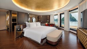Een moderne hotelkamer met een groot bed, een bureau en uitzicht op zee.