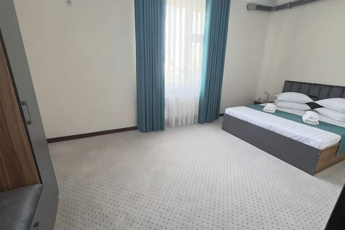 Un dormitorio con cama, cortinas y ventana.