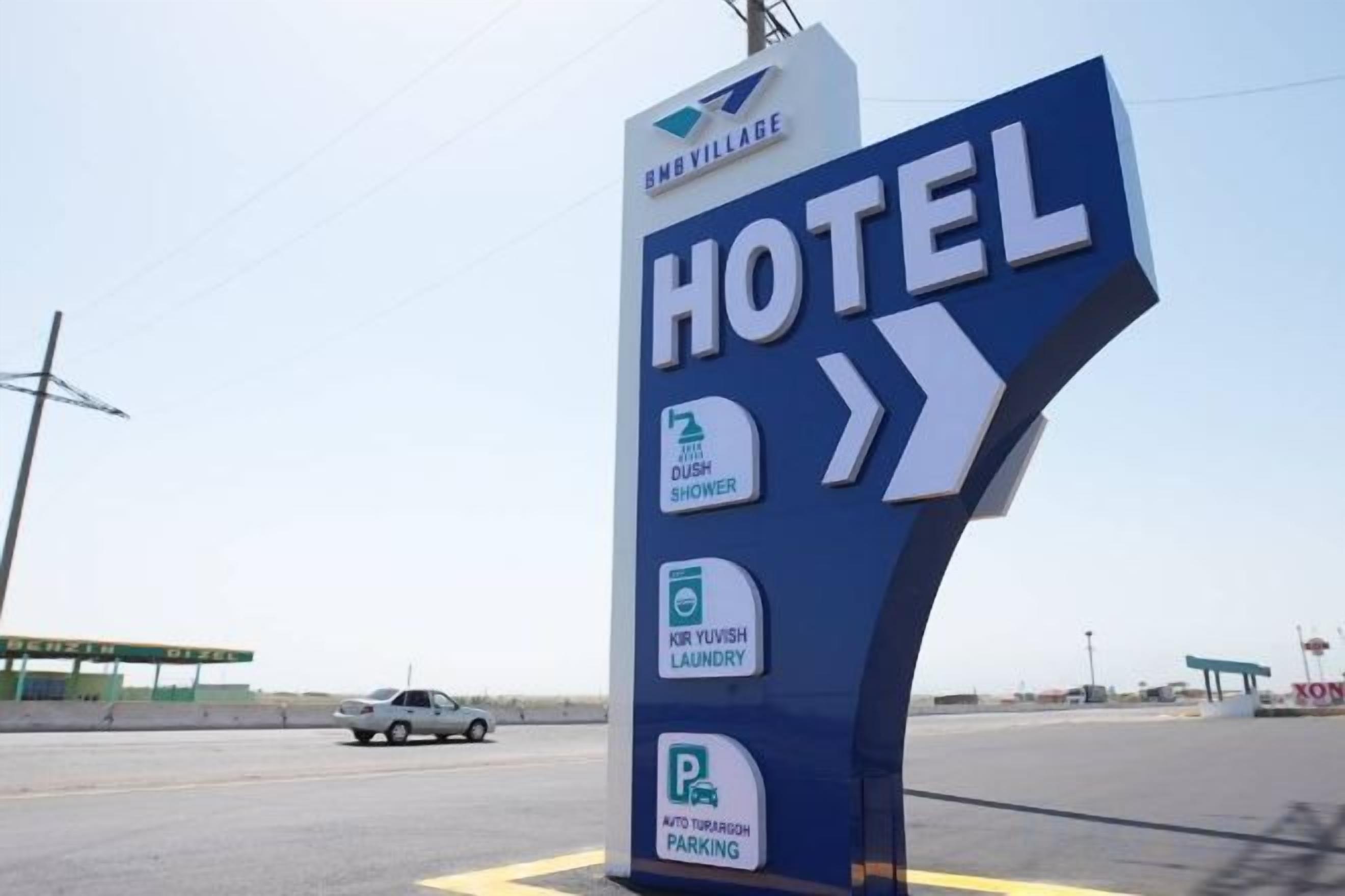 A hotel sign with amenities including a rush shower, Kur Yuvish laundry, and auto-rickshaw parking.