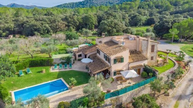A villa with a swimming pool, outdoor seating, and a view of the surrounding forest. - REYNES - Rustic villa with private pool and free Wi-Fi (Pollensa)
