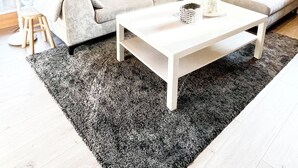 Uma sala de estar acolhedora com um sofá, uma mesa de centro e um tapete.