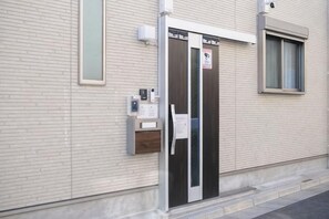 Una entrada de edificio con puerta, ventana y buzón.