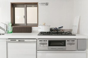 A kitchen with a stove, a dishwasher, and a window. - QiQi House Serenity~Private Near Asakusa & Skytree (Tokyo)