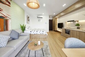 A modern living room with a sofa, a coffee table, and a dining area. - HaChu House (Hanoi)