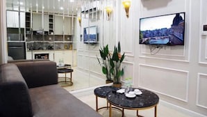 Una sala de estar moderna con un sofá, una mesa de centro y un televisor montado en la pared.