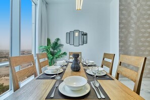 Una mesa de comedor dispuesta con platos, vasos y cubiertos, con un adorno decorativo en la pared superior.