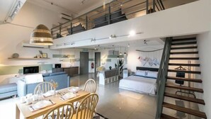A modern interior with a dining area, a staircase, and a living space. - Pinnacle Duplex@5m Walk to Paradigm Mall+WIFI (Petaling Jaya)