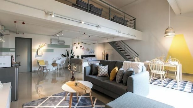 A modern living space with a sofa, dining table, and chairs. - Pinnacle Duplex@5m Walk to Paradigm Mall+WIFI (Petaling Jaya)
