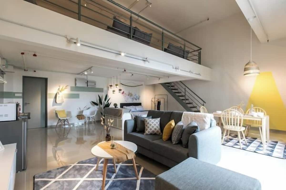 A modern living space with a sofa, dining table, and chairs.