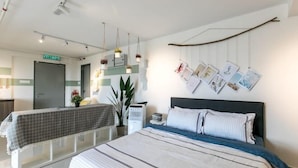 A hotel room with a bed, bedside tables, a wall-mounted photo display, and a visible exit sign. - Pinnacle Duplex@5m Walk to Paradigm Mall+WIFI (Petaling Jaya)