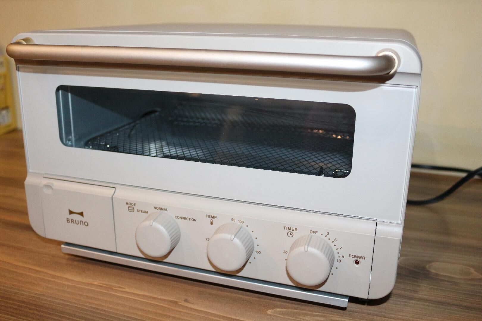 Horno tostador blanco con pantalla digital y mandos para la temperatura, el temporizador y la configuración de potencia.