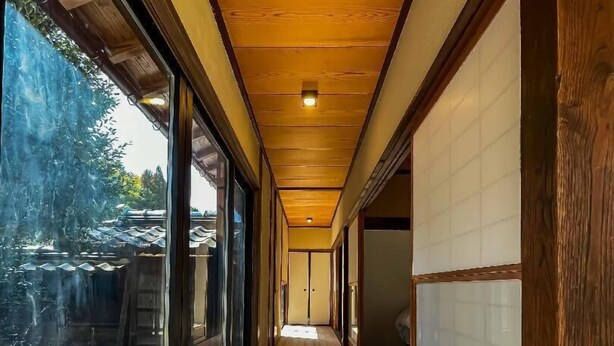 A corridor with wooden flooring, large windows, and a view of the outdoors. - Takeda Base Inn (Asago)