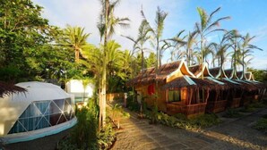 A resort with a dome-shaped building and traditional huts with thatched roofs. - Carabao Island Beach Camp (San Jose)