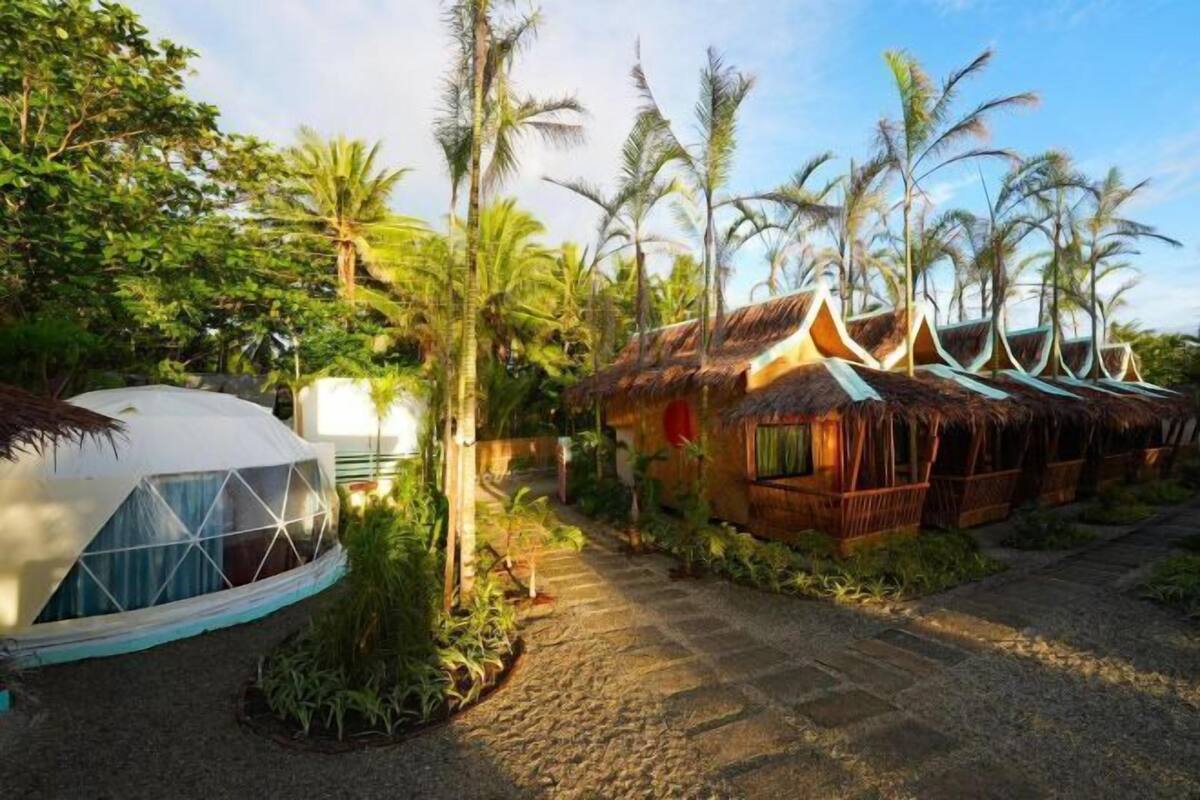 A resort with a dome-shaped building and traditional huts with thatched roofs.
