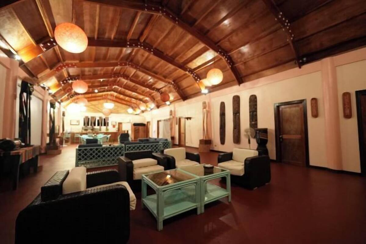 A spacious lobby with a high wooden ceiling, comfortable seating, and a central coffee table.