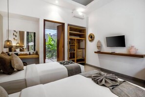 A hotel room with a bed, a TV, a shelf, and a wardrobe. - Villa Sarang Cocoon Ubud by BaliSuperHost (Bali)