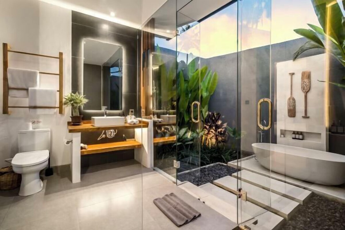 Une salle de bain moderne dotée d’une douche à parois de verre, d’une baignoire sur pieds et d’un meuble-lavabo avec miroir.