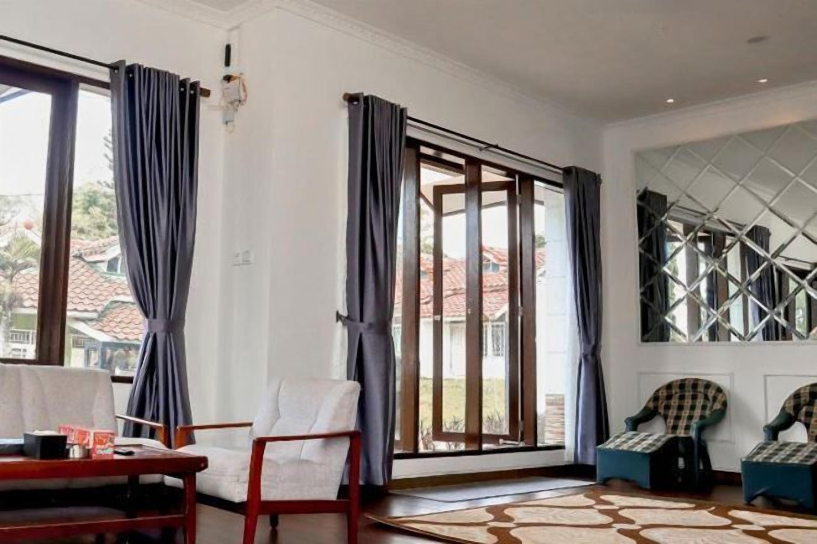 A room with a large sliding glass door, a patterned rug, and two chairs.
