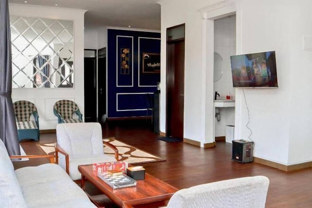 A modern living room with a sofa, chairs, a coffee table, and a TV.