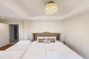 A bedroom with a large bed, a tufted headboard, and a chandelier. - Villa Primo Khaoyai near Toscana (Pak Chong)