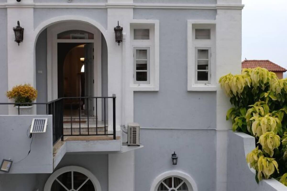 A building with a balcony, a door, and a window.