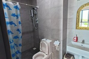Un baño con ducha, inodoro y lavabo.