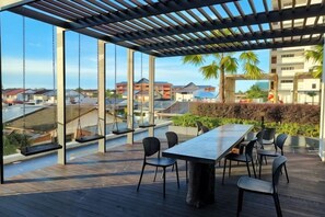 Un patio al aire libre con una mesa y sillas, con vistas a un paisaje urbano.