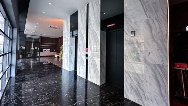 A modern hotel lobby with marble flooring, a reception desk, and a staircase. - LittleChing @ Armadale Residence Galacity (Kuching)