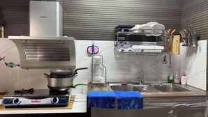 A kitchen with a stove, sink, and dish rack. - Nha Cua Bot – 5BR 4BA in DaLat (Dalat)